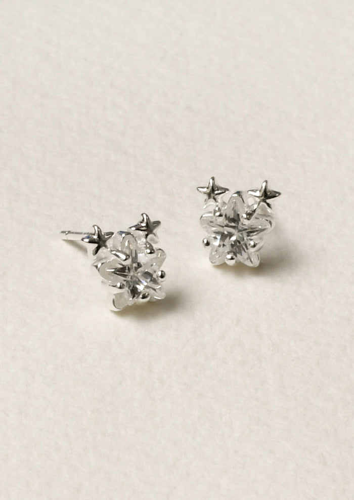 A pair of sterling silver star shaped cubic zirconia earrings with two tiny stars on the tops of each earring.