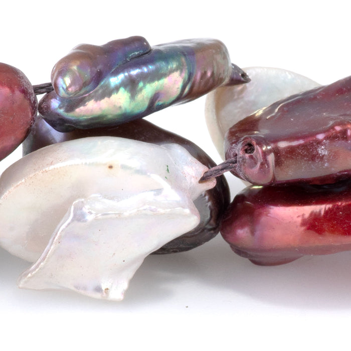 This is a Dakota Stones 14x15-17mm Freshwater Pearl Color Mix Flat Gemstone strand with oval beads in 15-16 inch strand.