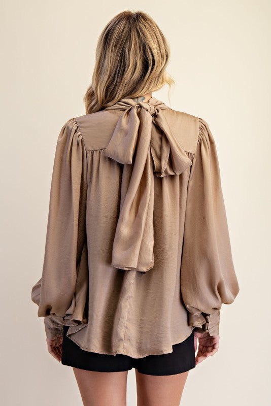 Women's taupe shimmering satin mock neck top with bow tie back showing back view