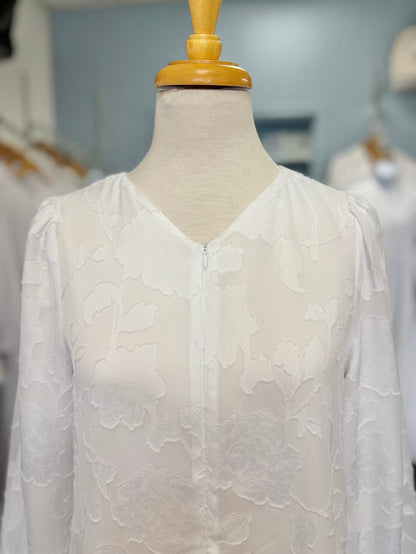 Long white dress with floral appliques and zipper front.