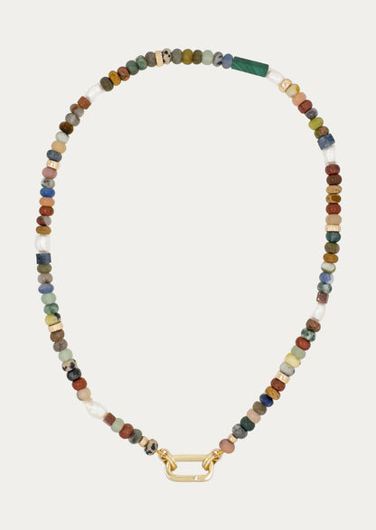 A gold carabiner necklace adorned with various colored gemstones in muted tones.