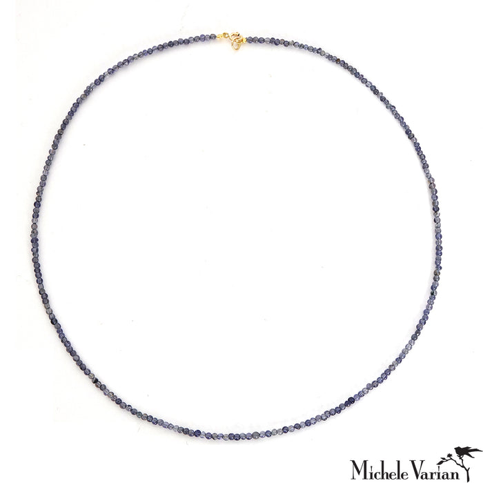 A blue-grey beaded necklace with a 14k closure, on a white background