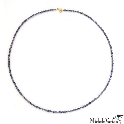 A blue-grey beaded necklace with a 14k closure, on a white background