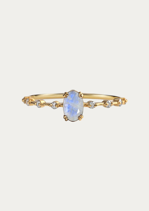 A gold ring with a natural oval moonstone in the center and cubic zirconia along the band.