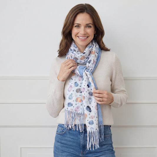 Woman wearing a patterned scarf and smiling against a white background