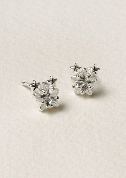 A pair of sterling silver star shaped cubic zirconia earrings with two tiny stars on the tops of each earring.