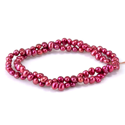 This is a Dakota Stones 5-6mm Freshwater Pearl Pink Red Flat Gemstone strand with irregular oval beads in 15-16 inch strand.