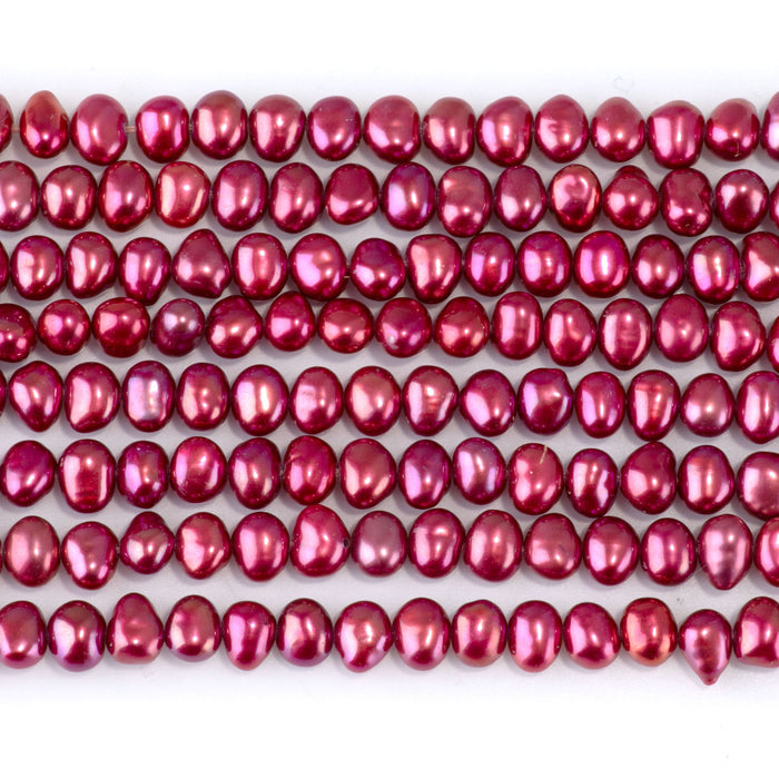 This is a Dakota Stones 5-6mm Freshwater Pearl Pink Red Flat Gemstone strand with irregular oval beads in 15-16 inch strand.