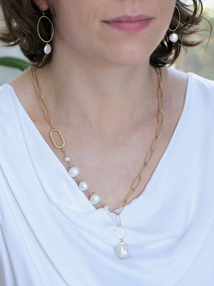 Model wearing the Grace Pearl NH Necklace from Ardor Boutique, showcasing its asymmetrical matte gold chain, freshwater pearls, and baroque pearl drop.