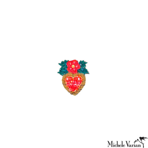 Heart-shaped brooch with red floral design on a white background