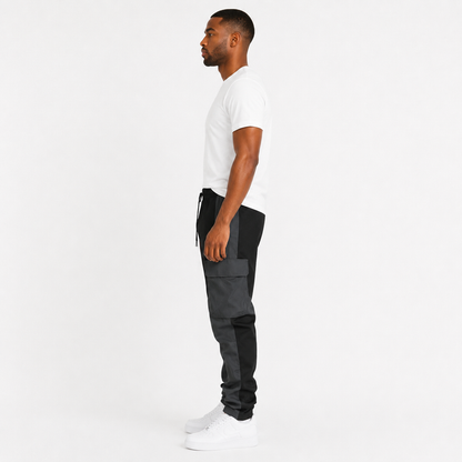 Men's black cargo trousers side view showing large flap pocket and two-tone panel design