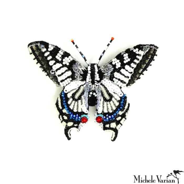 Butterfly-shaped decorative item with beads on a white background