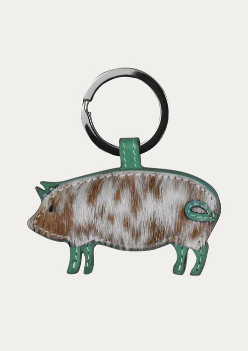 A leather pig keychain in with a turquoise border.