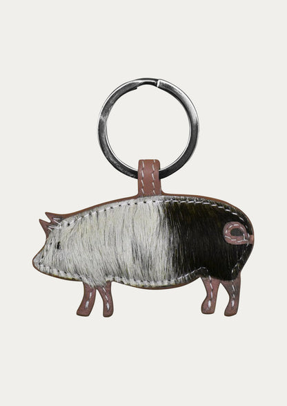A leather pig keychain in with a mauve border.