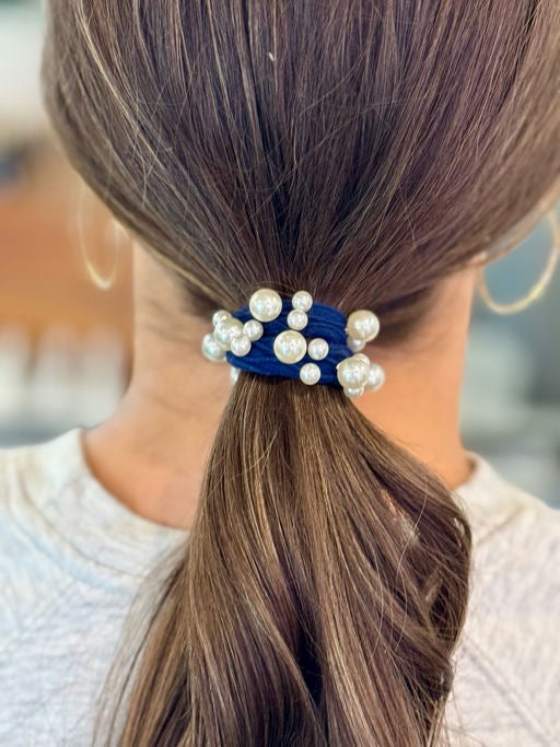 Hair tie with pearls and blue accents in a ponytail