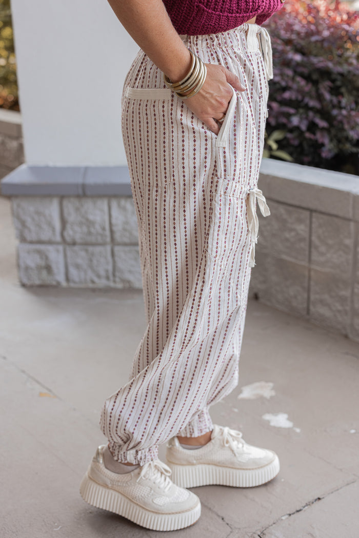 Women's oatmeal cargo jogger pants with redish brown and caramel print stripes by ee:some showing up close side view
