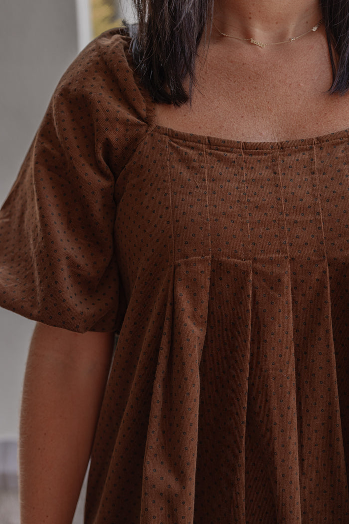 Women's brown pleated corduroy dress with black polkadots by Wishlist showing up close view of pleated details