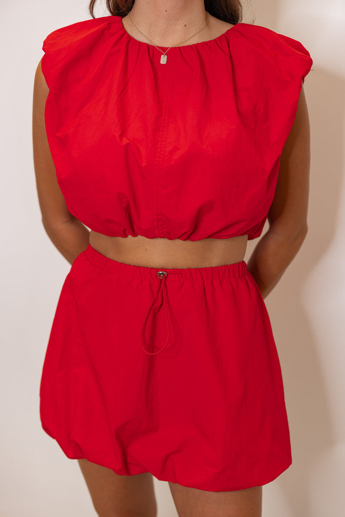 Women's red bubble hem crop top and matching mini skirt set by Day & Moon showing up close front view