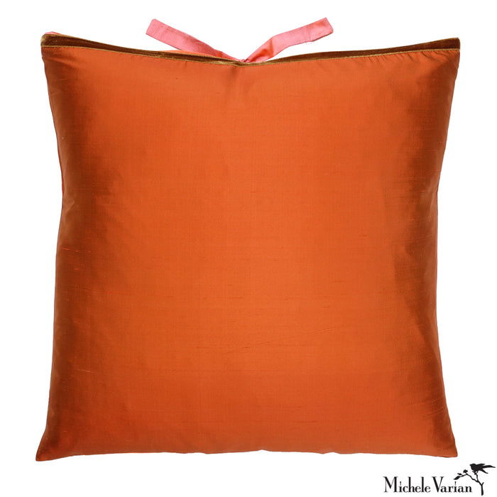 Orange silk pillow with a pink silk closure on a white background. Designed by Michele Varian.