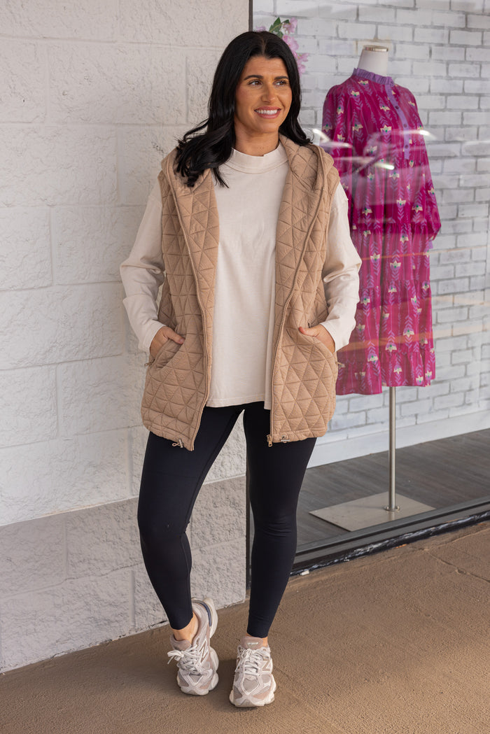 Women's taupe quilted knit puffer vest with hood and cinch hem by She + Sky showing full front view