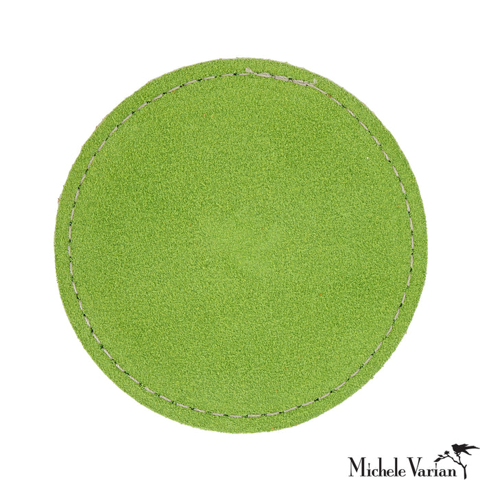 Lime green circular drink coaster with white stitching on a white background.