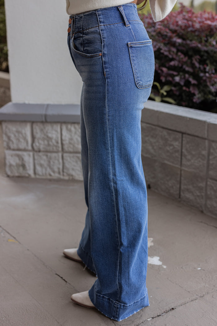 Risen Jeans dark wash denim jeans with wide ankle seam detail showing up close side view