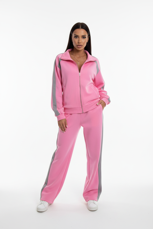 Woman in pink co-ord tracksuit set stretching outdoors, morning workout outfit, soft natural lighting